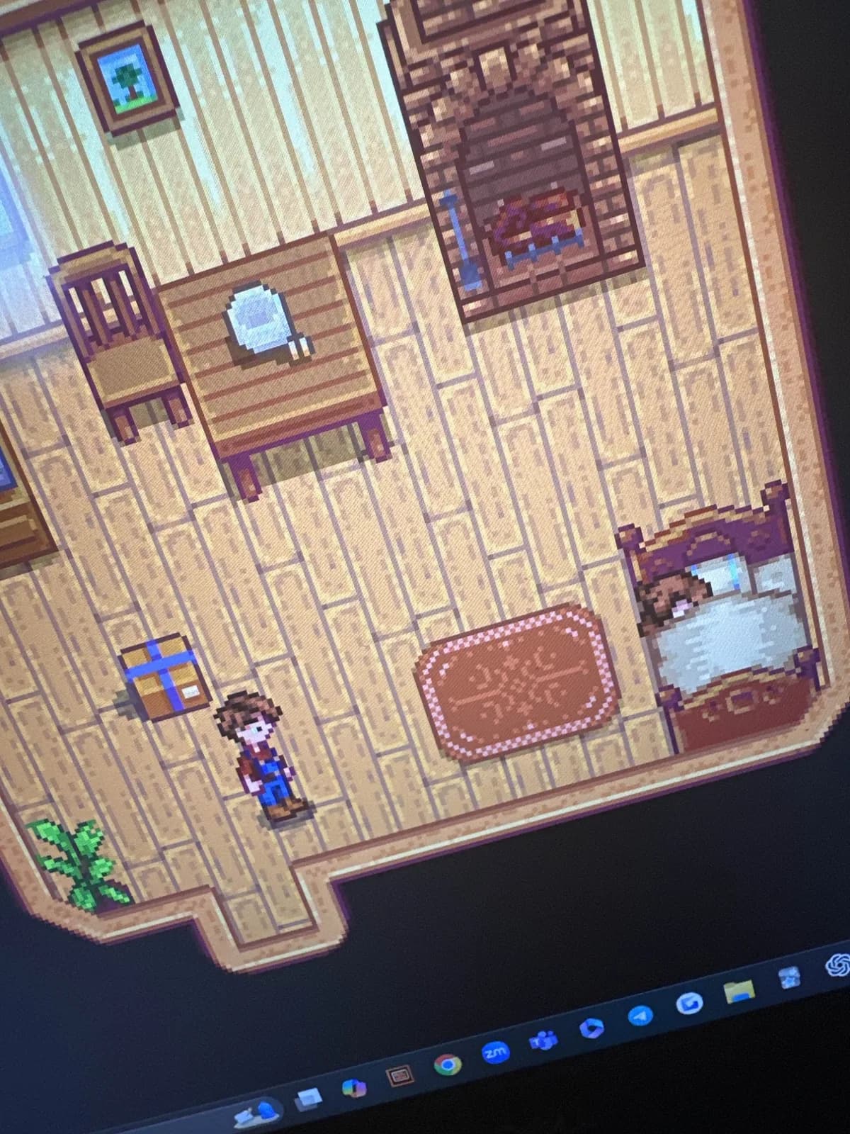 A farmhouse room in Stardew Valley with the player character, a gift box, and a bed