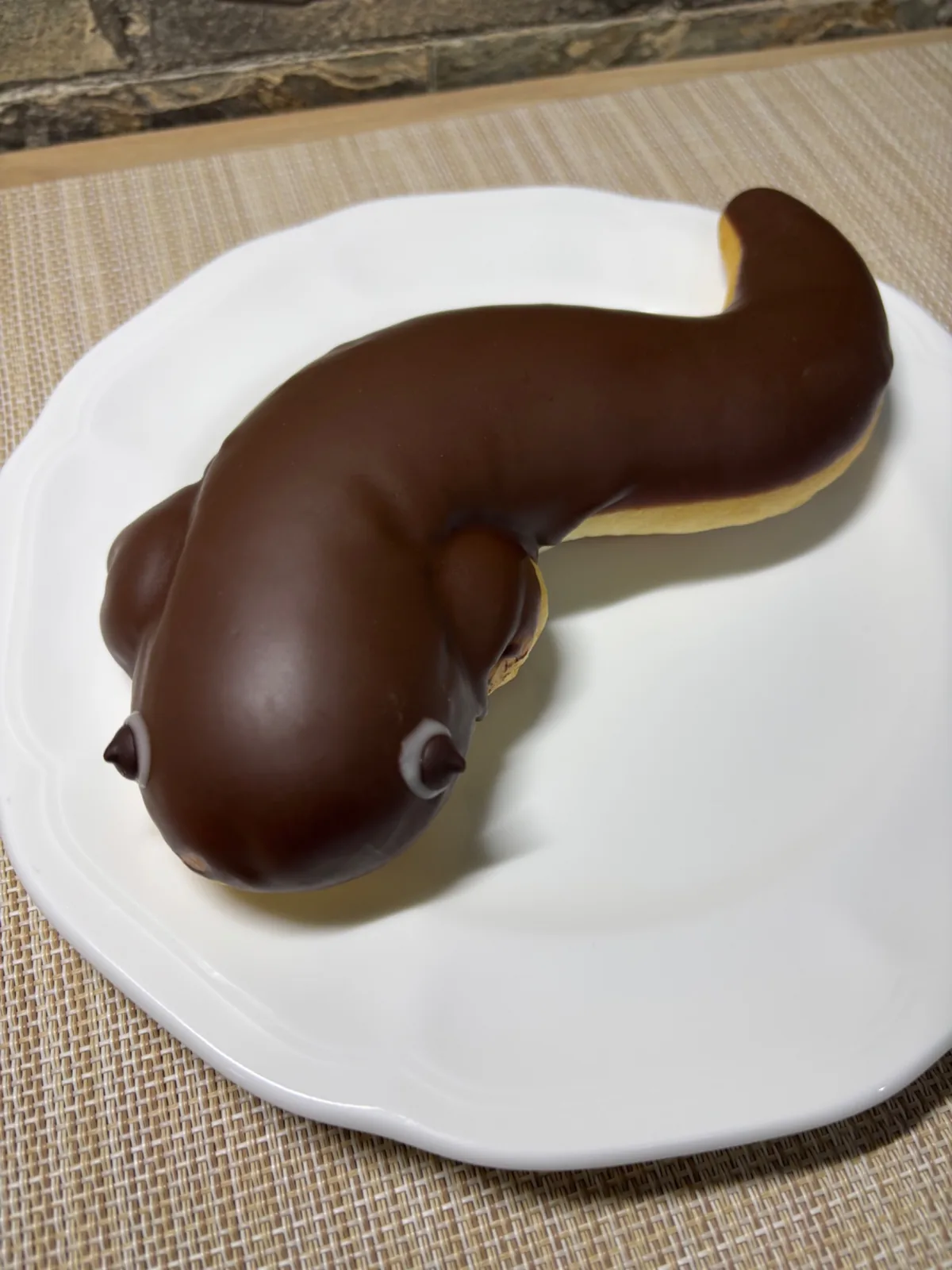 Chocolate-covered eel-shaped bread on a white plate