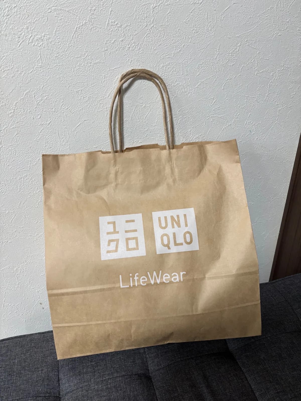 A UNIQLO paper shopping bag after a clothing shopping trip