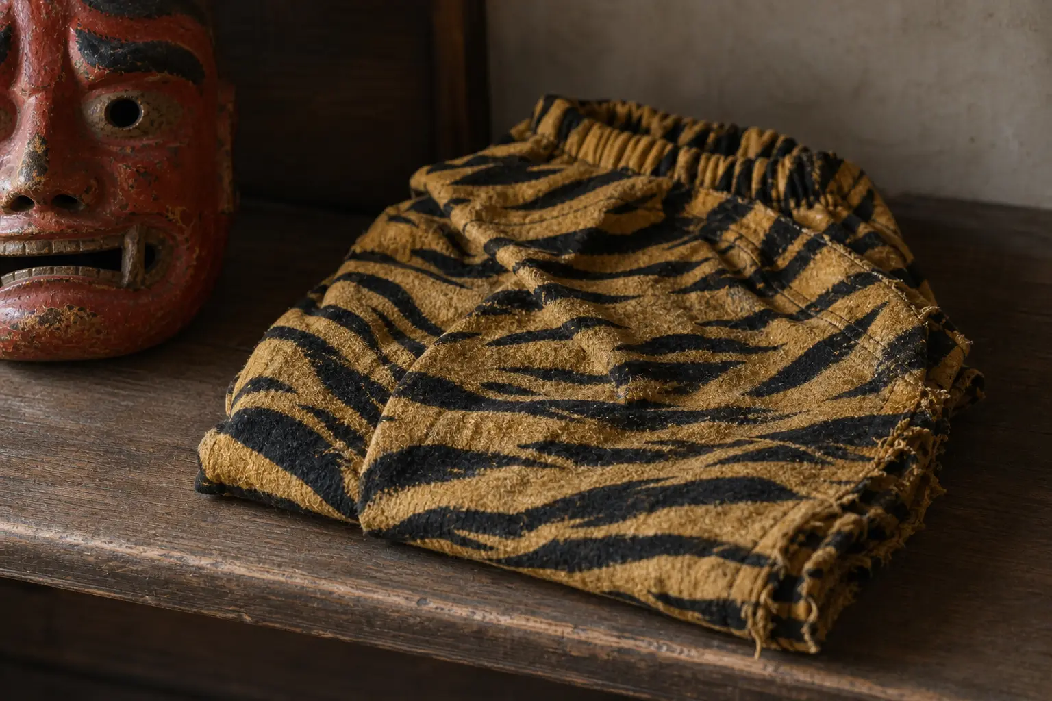 Tiger-pattern oni costume fabric beside an oni mask